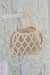 pearl polyester crossbody handbag, white pearls, rear view, hanging from doorknob