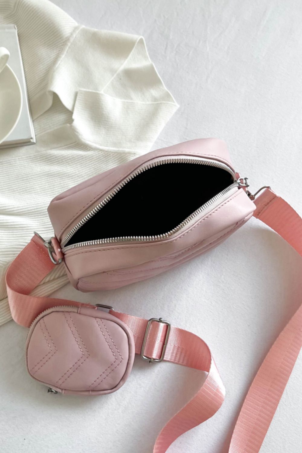 pu leather shoulder handbag with small purse, blush pink, top-down view of open handbag on bed