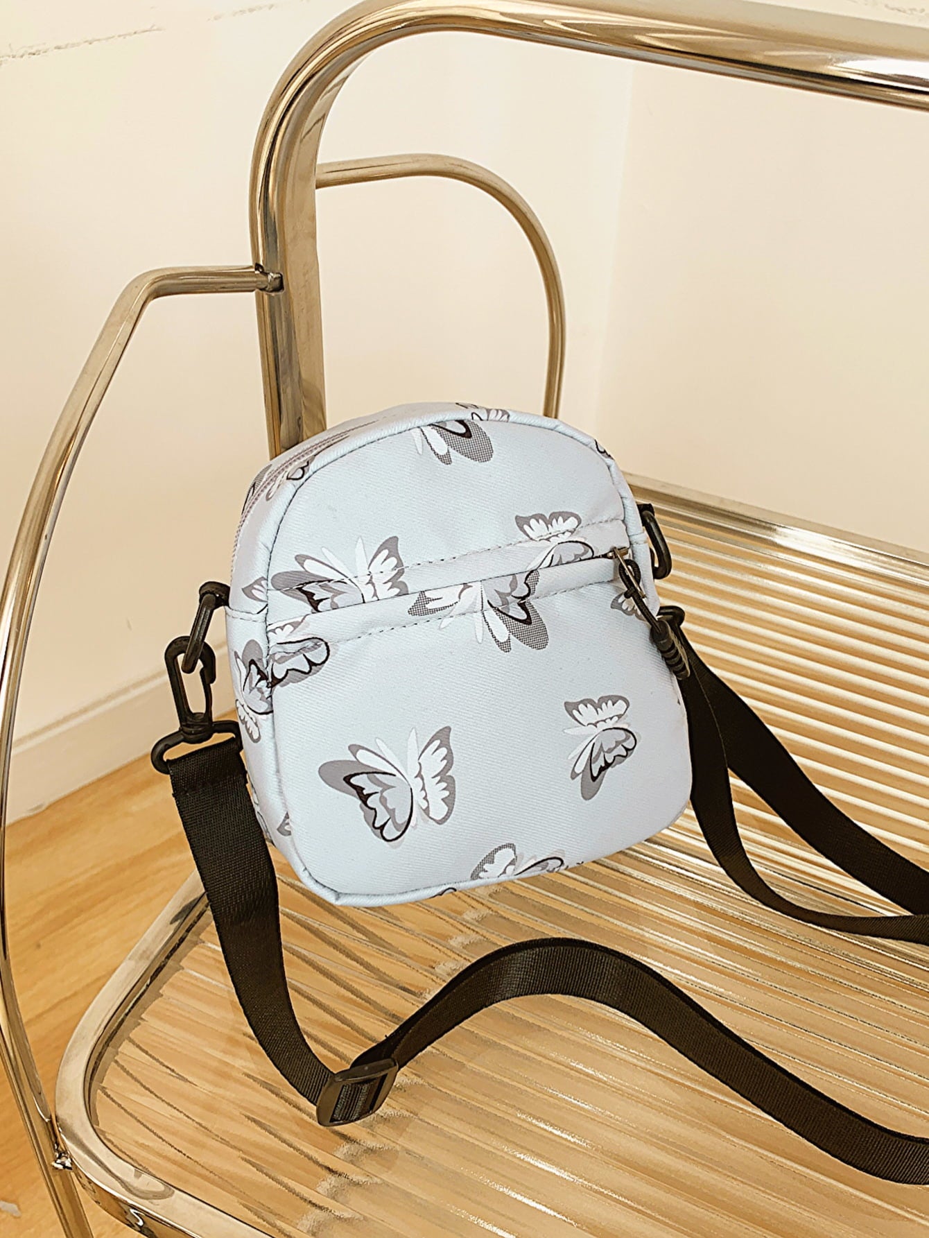 butterfly print polyester shoulder handbag, gray with gray butterflies, on glass and metal slatted cart