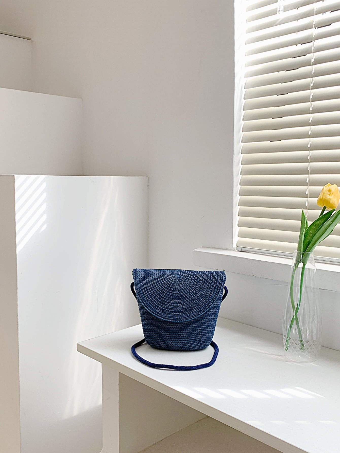crochet shoulder handbag, angled view, on white countertop against window with white window blinds