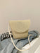 crochet shoulder handbag, tan, atop a denim jacket