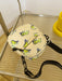 butterfly print polyester shoulder handbag, yellow with green butterflies, flat view, atop glass and metal slatted cart