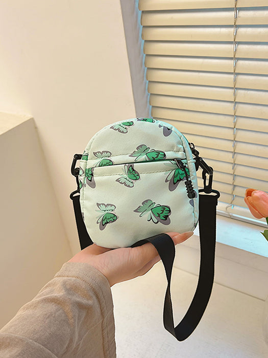 butterfly print polyester shoulder handbag, green with green butterflies, held at arm's length in the palm of a woman's hand