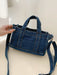 denim shoulder handbag, dark blue, angled view, held by woman's hand