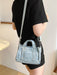 denim shoulder handbag, light blue, hanging from a person's shoulder
