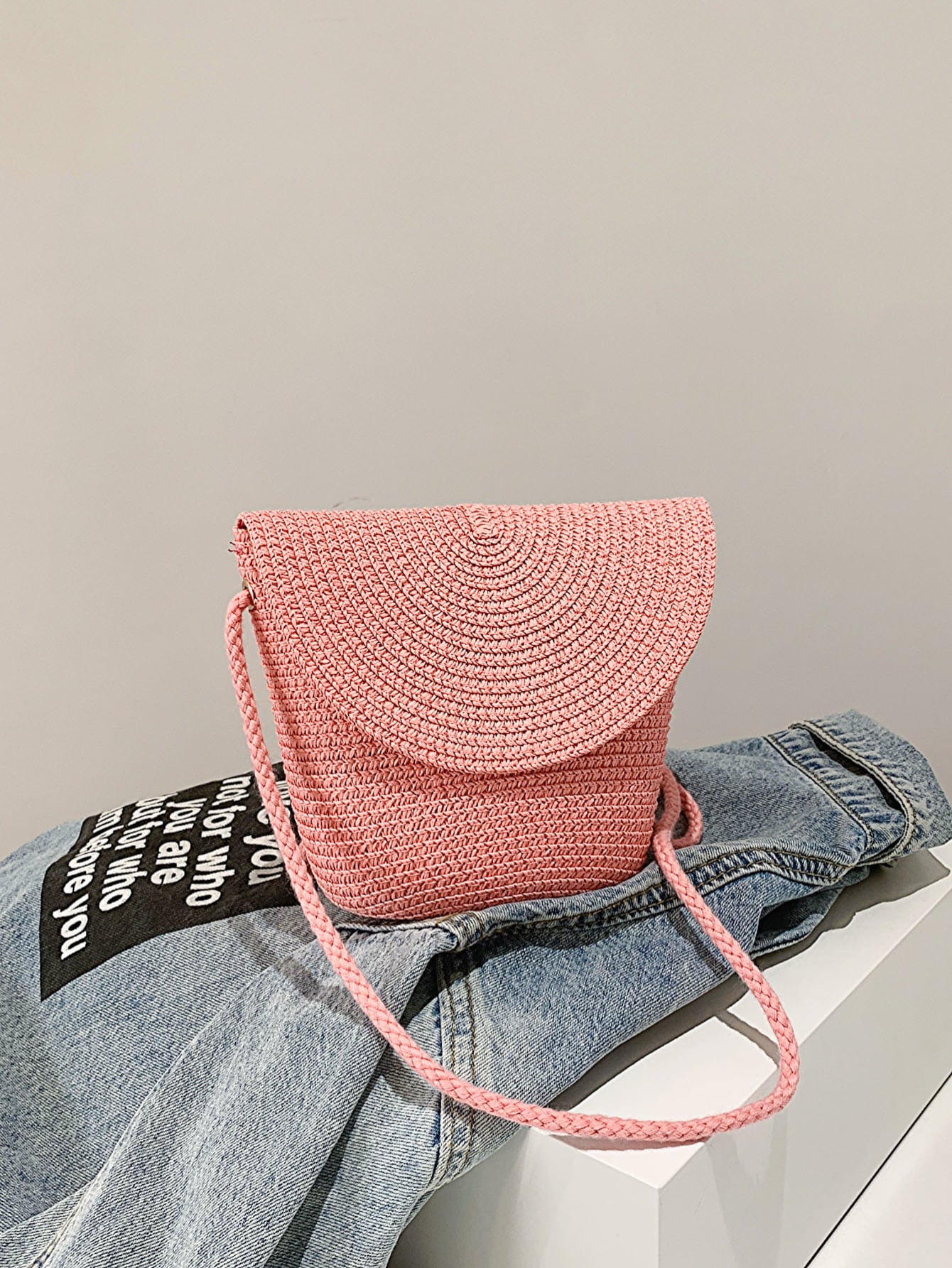 crochet shoulder handbag, blush pink, front view atop denim jacket