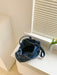 denim shoulder handbag, dark blue, top-down interior view, on white countertop